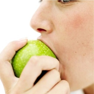 Une personne mange une pomme.